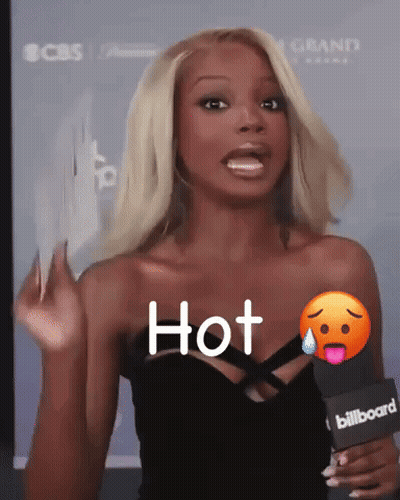 A Woman Is Holding A Microphone That Says Hot GIF