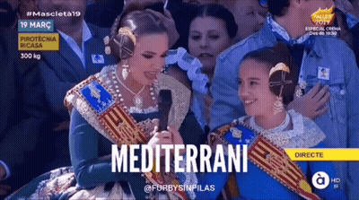 A Woman Is Holding A Microphone With The Word Mediterrane On The Screen GIF
