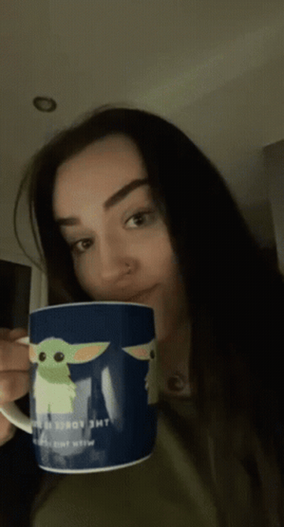 A Woman Is Holding A Mug That Says The Child GIF