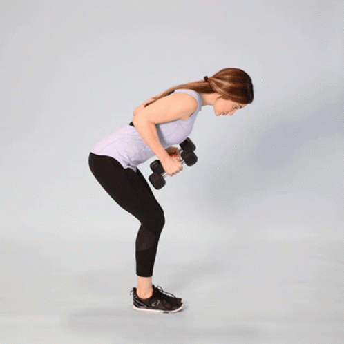 A Woman Is Holding A Pair Of Dumbbells While Bending Over GIF