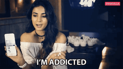 A Woman Is Holding A Phone And Says I 'M Addicted GIF