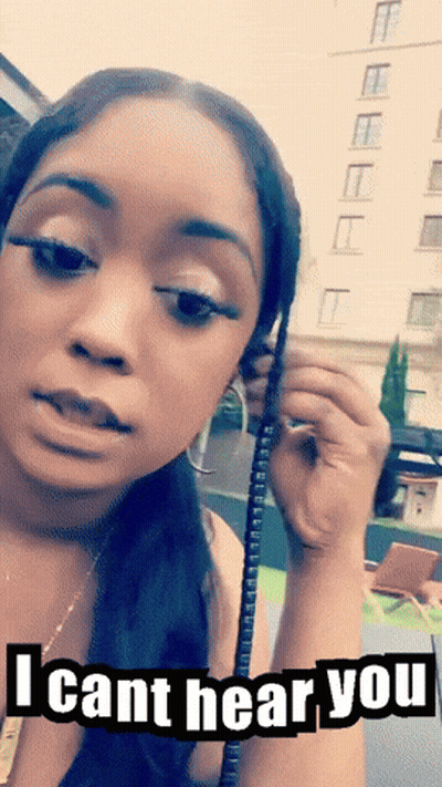 A Woman Is Holding A Phone With The Words I Cant Hear You On The Bottom GIF