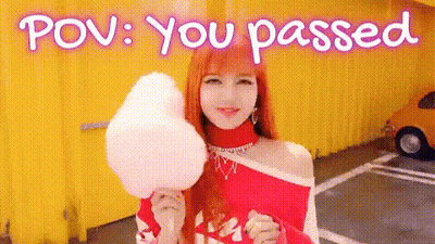 A Woman Is Holding A Piece Of Cotton Candy In Front Of A Yellow Building . GIF