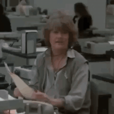A Woman Is Holding A Piece Of Paper And Saying Atta Girl GIF