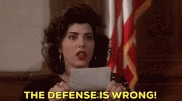 A Woman Is Holding A Piece Of Paper In Her Hand And Says The Defense Is Wrong . GIF