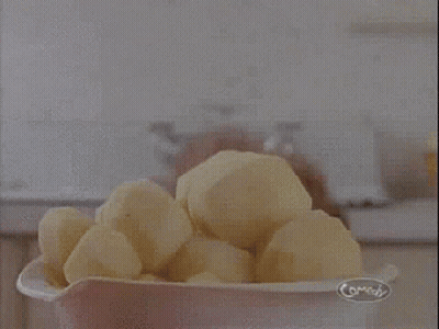 A Woman Is Holding A Pile Of Potatoes And Says Potatoes ! GIF