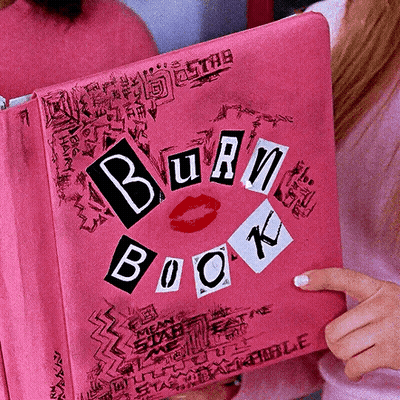 A Woman Is Holding A Pink Burn Book With A Kiss On It GIF