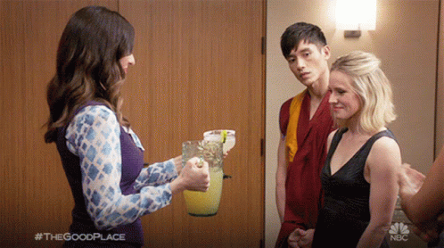 A Woman Is Holding A Pitcher Of Lemonade In Front Of A Man And A Woman With #Thegoodplace Written In The Corner GIF