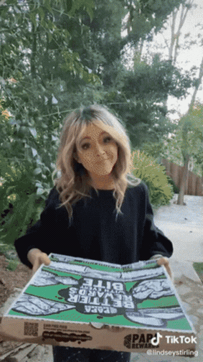 A Woman Is Holding A Pizza Box That Says Papa John 'S On It GIF