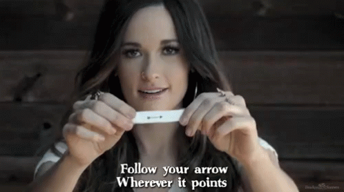 A Woman Is Holding A Pregnancy Test In Her Hands With The Words Follow Your Arrow Wherever It Points . GIF
