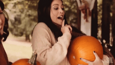 A Woman Is Holding A Pumpkin With The Word Snl On The Bottom GIF