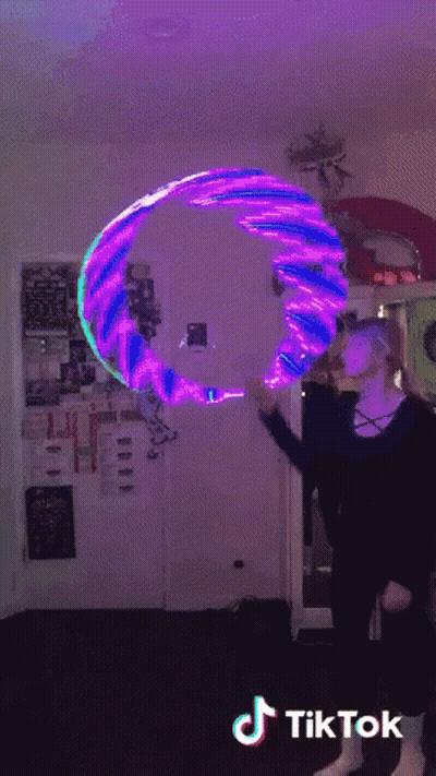 A Woman Is Holding A Purple And Blue Hula Hoop With Tiktok Written On The Bottom Right GIF