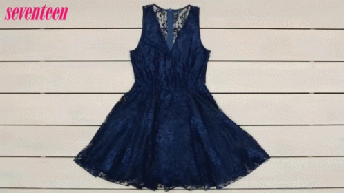 A Woman Is Holding A Purse In Front Of A Blue Dress GIF