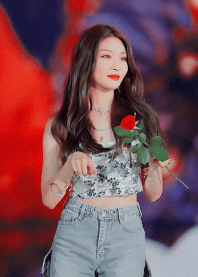 A Woman Is Holding A Red Rose In Her Hand GIF