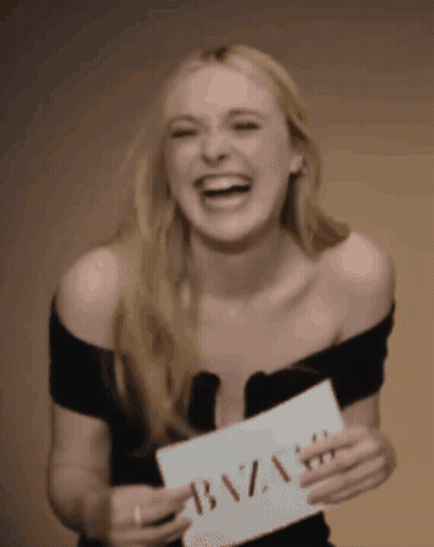 A Woman Is Holding A Sign That Says Bazaar GIF