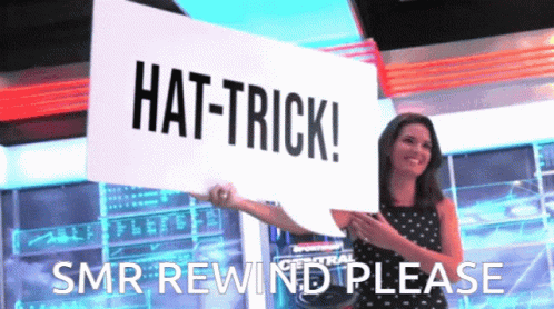 A Woman Is Holding A Sign That Says Hat-Trick GIF
