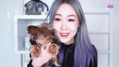 A Woman Is Holding A Small Brown Dog In Her Arms And The Word Muse Is On The Bottom GIF