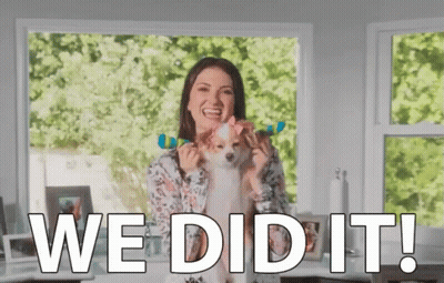 A Woman Is Holding A Small Dog With A Bow On Its Head And Says We Did It ! GIF