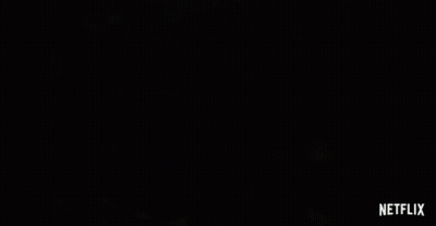 A Woman Is Holding A Sword In The Water With A Netflix Logo Behind Her GIF