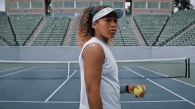 A Woman Is Holding A Tennis Ball On A Court GIF