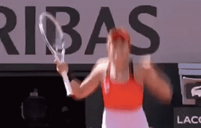 A Woman Is Holding A Tennis Racket In Front Of A Large Sign That Says Ribas . GIF