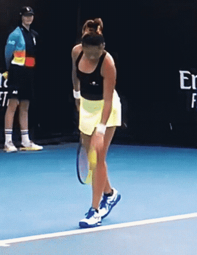 A Woman Is Holding A Tennis Racket On A Blue Court GIF