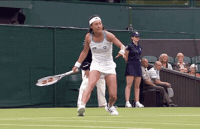 A Woman Is Holding A Tennis Racket On A Tennis Court GIF