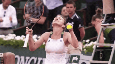 A Woman Is Holding A Tennis Racquet And A Tennis Ball While Playing Tennis GIF