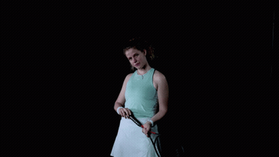A Woman Is Holding A Tennis Racquet In Her Hand GIF