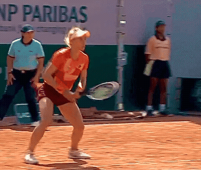A Woman Is Holding A Tennis Racquet On A Court In Front Of A Sign That Says Np Paribas GIF