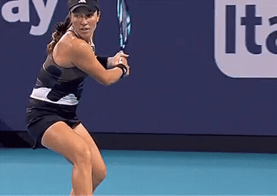 A Woman Is Holding A Tennis Racquet On A Court In Front Of An Advertisement For Lte GIF