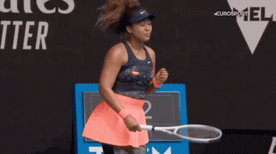 A Woman Is Holding A Tennis Racquet On A Tennis Court And Celebrating . GIF