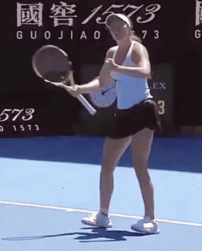 A Woman Is Holding A Tennis Racquet On A Tennis Court In Front Of A Scoreboard . GIF