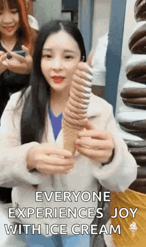 A Woman Is Holding A Very Long Ice Cream Cone And Says `` Everyone Experiences Joy With Ice Cream '' . GIF