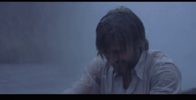 A Woman Is Holding A White Cloth Over Her Head In The Rain . GIF
