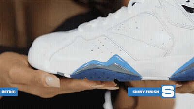 A Woman Is Holding A White Shoe With A Shiny Finish On The Bottom GIF