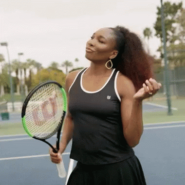 A Woman Is Holding A Wilson Tennis Racquet On A Tennis Court GIF