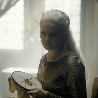 A Woman Is Holding An Embroidery Hoop With A Butterfly On It GIF
