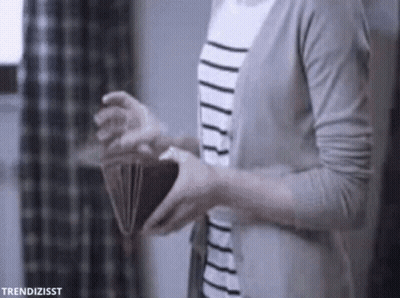 A Woman Is Holding An Open Wallet In Her Hands . GIF