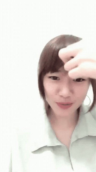 A Woman Is Holding Her Hair Up In A Ponytail . GIF