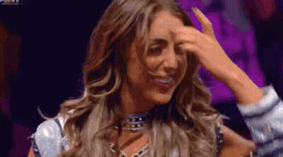A Woman Is Holding Her Hand To Her Forehead . GIF