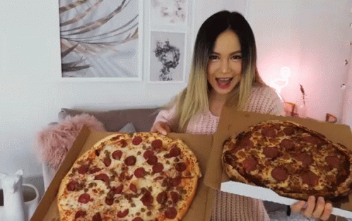 A Woman Is Holding Two Pizzas In Her Hands One Of Which Has Pepperoni On It GIF