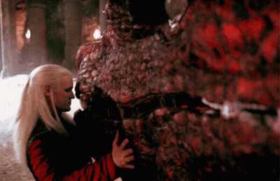 A Woman Is Hugging A Monster That Is Covered In Red Spots GIF