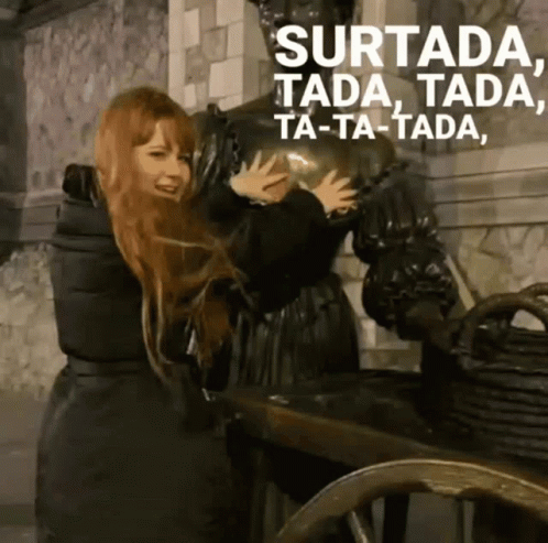 A Woman Is Hugging A Statue With The Words Surtada Ta-Ta-Tada Ta-Ta-Tada Written Above Her GIF
