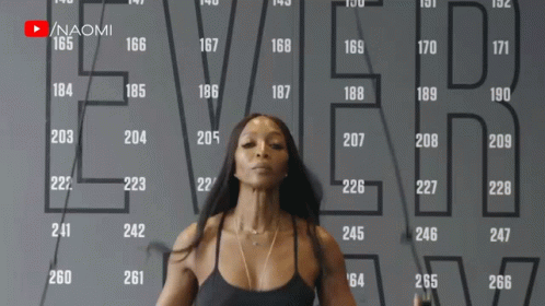 A Woman Is Jumping A Jump Rope In Front Of A Wall That Says Ever On It GIF