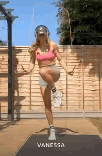 A Woman Is Jumping A Jump Rope While Wearing Headphones And A Hat . GIF