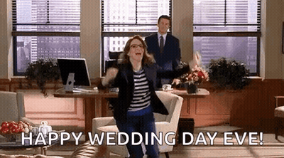 A Woman Is Jumping In The Air In An Office While A Man Stands Behind Her And Says Happy Wedding Day Eve . GIF