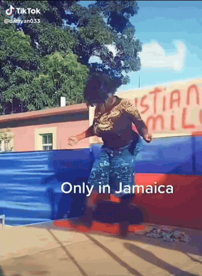 A Woman Is Jumping In The Air In Front Of A Sign That Says Christian Mill GIF