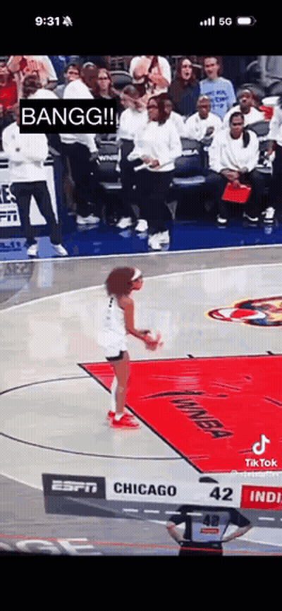 A Woman Is Jumping In The Air On A Basketball Court While A Crowd Watches . GIF