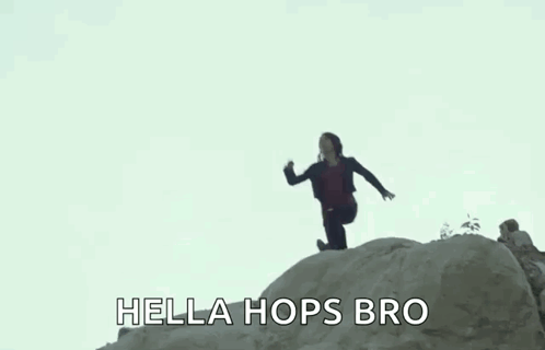 A Woman Is Jumping Off A Rock With The Words `` Hella Hops Bro '' Written Below Her . GIF
